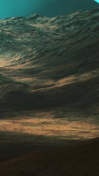 Waves crash along the shore as the sun sets in the background. Shadows from the hills contrast with the golden light on the waters surface. The scene captures natures movement.