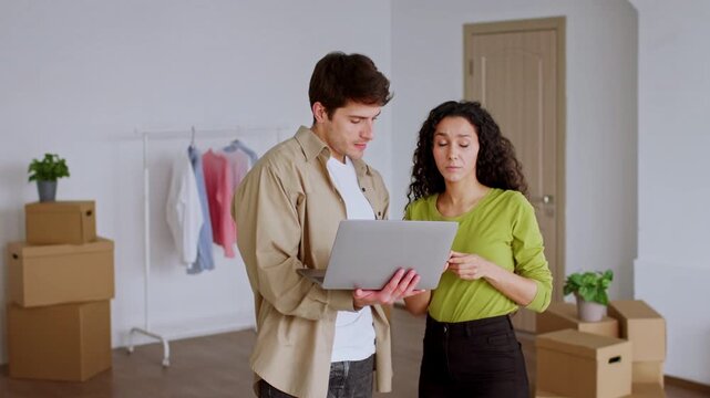 Focused Woman And Man Engaging With Laptop, Discussing Ideas In Bright Office Space, Surrounded By Moving Boxes, Representing Collaboration And New Beginnings In Business Concept.