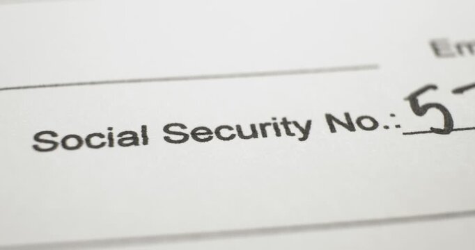 Closeup of Social Security number text on paperwork and writing the SSN. Document requiring identification by means of a persons social security number.