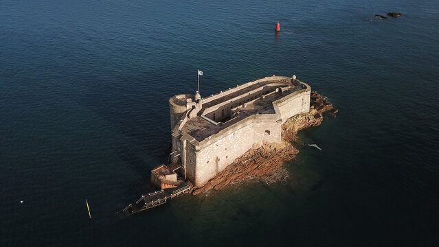 Aerial view of the historic Chateau du Taureau fortress situated on a rocky islet in the sea, featuring stone walls and a flag, Carantec, Bretagne, France.