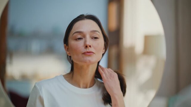 Woman examining face mirror searching aging signs closeup. Lady studying skin