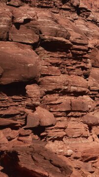 Numerous rocks and layers are visible in a dry desert area under bright daylight. The scene shows earthy tones and textures created by natural weathering and erosion.