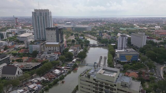 Aerial view of Surabaya downtown area, tower buildings, river, bridge and old sluice gate