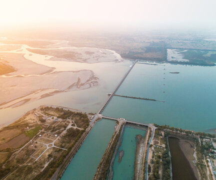 Aerial view of Head Marala - Chenab View Point showing the dam structure and water channels of the Chenab River at sunset in Sialkot, Punjab, Pakistan.