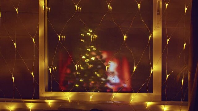 Warm Christmas Window With Golden Fairy Lights Reflecting a Decorated Tree and Fireplace, Cozy Holiday Home, Festive Atmosphere and Winter Comfort