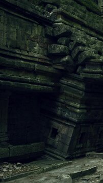 A large stone structure shows signs of age and wear. Trees surround the area, and sunlight filters through the leaves, creating a natural setting. The place seems forgotten over time.