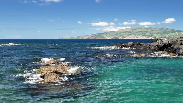 Azores, Pico Island, Portugal. Coastal view across the Atlantic Ocean toward Faial Island, featuring volcanic scenery and the peaceful natural beauty of the Azorean archipelago.