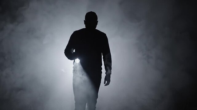 Man with flashlight in dense fog mystery exploration
