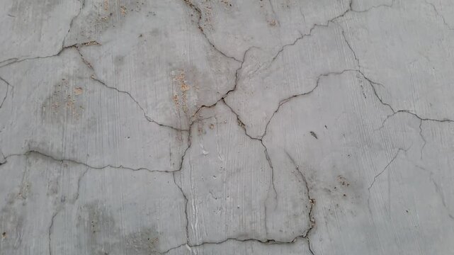 Cracked exterior house wall with mold, grass, and exposed white brick. Damaged plaster texture outdoor. Building deterioration stock video 4K for inspection, construction, repair, maintenance, estate.