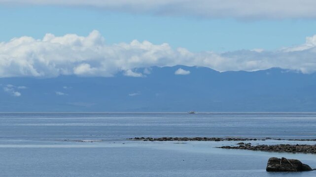 Distant Boat on Calm Waters, Mountains and Clouds Over Vancouver Island