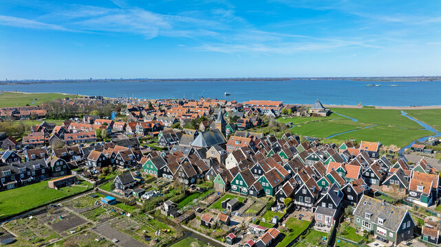 Aerial view of the historic village of Marken with its traditional wooden houses, narrow streets, and church tower, situated along the coast in Marken, North Holland, Netherlands.