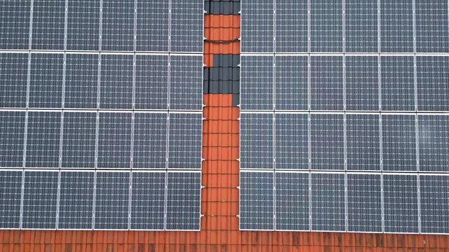Image scrolling up showing a view of solar panels installed on the roof of a house.Drone shot
