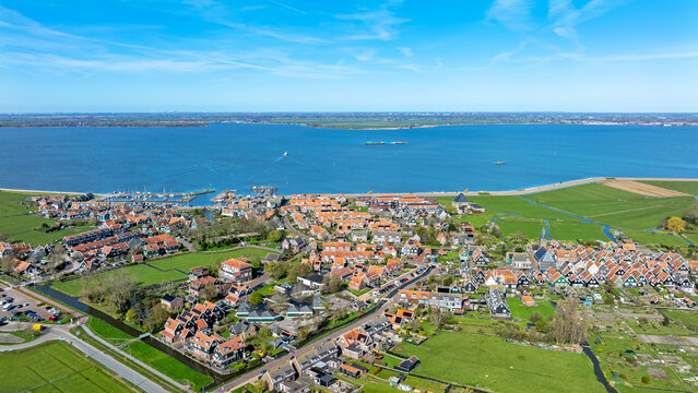Aerial view of the historic village of Marken with its characteristic wooden houses, harbor, and green fields along the Markermeer in Marken, North Holland, Netherlands.