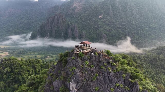 Vang Vieng, Laos - 07-02-2025: Aerial drone footage of the famous Nam Xay Viewpoint at the top of a limestone mountain in Laos, one of the famous karst landscape area in Southeast Asia.
