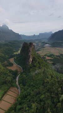 Vang Vieng, Laos - 07-02-2025: Aerial drone footage of the famous Nam Xay Viewpoint at the top of a limestone mountain in Laos, one of the famous karst landscape area in Southeast Asia.
