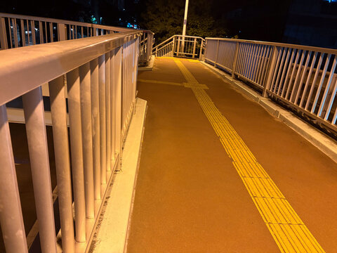 誰もいない歩道橋の夜景、街灯が照らす静寂な都市空間と夜道のイメージ素材