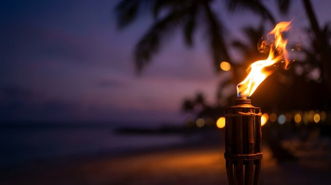 Tiki torch burning on a tropical beach at twilight with sunset sky