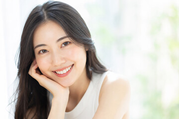 Fototapeta premium 頬杖をついてカメラを見つめ微笑む日本人女性 Generative AI