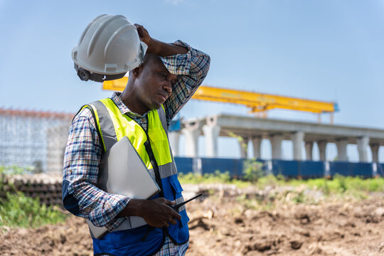 Exhausted engineer taking a break at construction site in heat, Manual labor in extreme weather, Worker man struggling with heat stress, Construction worker man wiping sweat under the hot sun