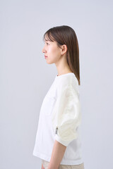 Fototapeta premium Young Japanese Woman with Serious Expression in White Top, Studio Portrait
