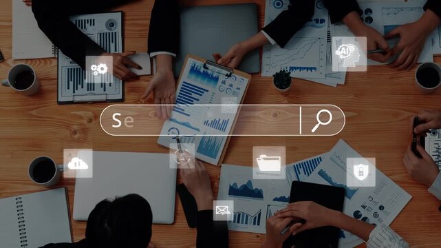 A diverse business team collaborates around a table filled with charts and graphs, using technology to streamline search and enhance strategic planning efforts. Raster