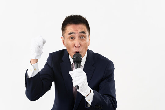 マイクを持ちながら選挙演説をするシニア男性