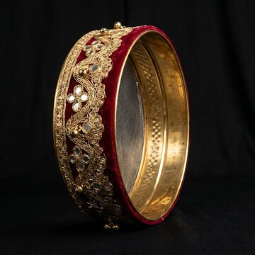 Traditional Indian Karwa Chauth Channi (Sieve): An ornate brass decorated sieve (channi) used in Hindu rituals, adorned with red velvet and gold lace borders, standing upright, black background, 1:1 r