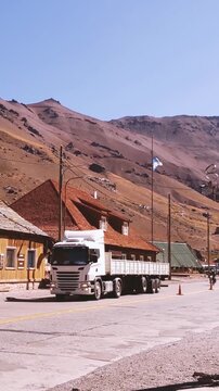 Cargo Truck And Motorcycle Driving On Highway At Argentina Border Town - 4K Vertical