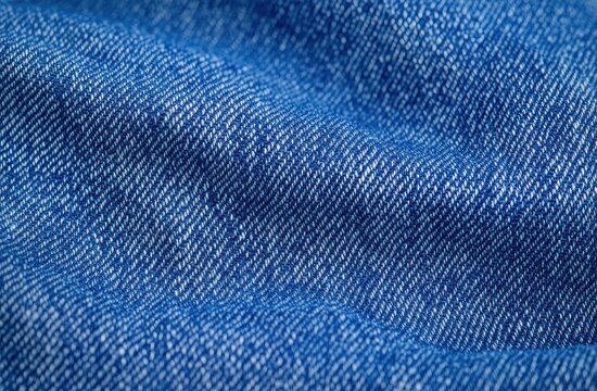 close-up of blue denim fabric with visible twill weave, threads and gentle folds conveying a cozy casual texture