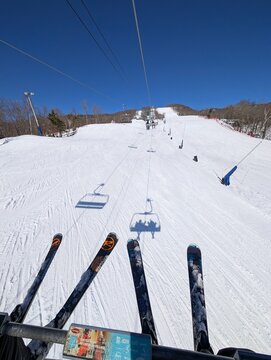 Skiing in winter - chairlift gondola and ski slopes for skiing and snowboarding  between trees on frosty day with beautiful views in  mountains