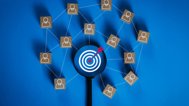 Business target audience analysis with magnifying glass focusing on a goal icon connected to a professional network. Concept of customer segmentation, recruitment, marketing strategy, HR, data 