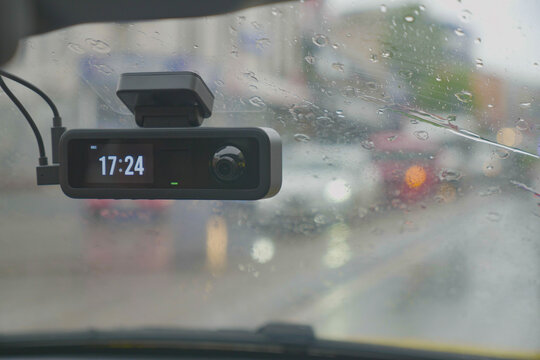 Dash Camera on Windshield in Rainy Traffic With Digital Time Display for Driving Safety