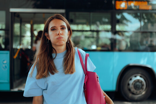 Stressed Woman Having Puffed Cheeks in front of a Bus. Anxious female traveler feels overwhelmed while waiting near public transit vehicle outdoors