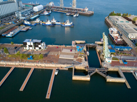 Aerial view of the Quebec City Port with tugboats docked at the pier, a lock system, and modern buildings along the waterfront in Quebec, Quebec, Canada.