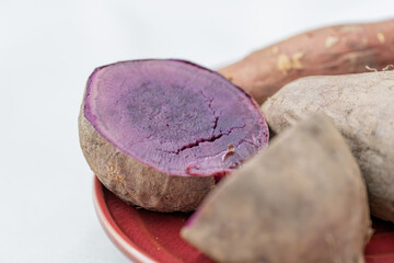 Naklejka premium Close up of steamed purple sweet potatoes arranged on red plate