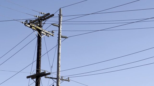 Cluttered power lines and utility poles. City of Honolulu, Oahu, Hawaii. An overhead power line is a structure used in electric power transmission and distribution to transmit electrical energy along 