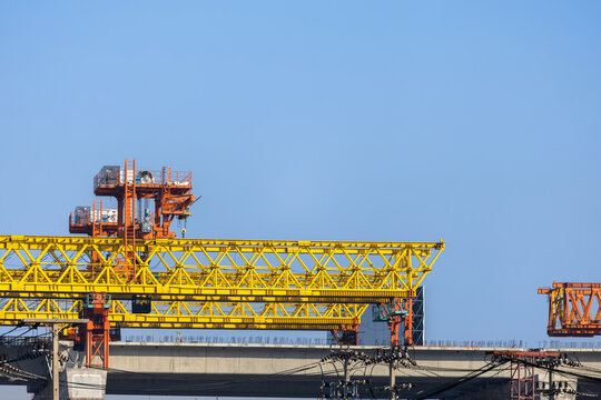 Large yellow gantry crane used for bridge construction and infrastructure projects, Heavy construction machinery , Industrial segment lifter crane working on concrete elevated road infrastructure