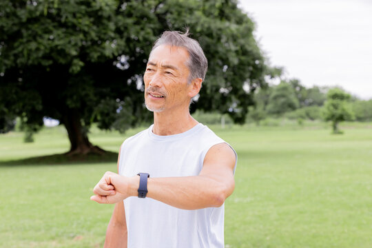 スマートウォッチで運動記録を確認するアクティブシニア男性