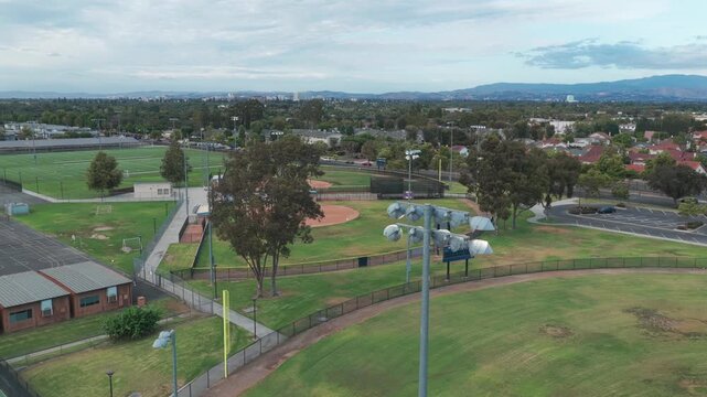 Aerial wide panning shot of a high school softball field in Southern California. 4K