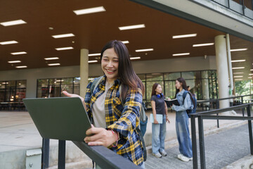 Fototapeta premium Happy university student using technology for campus learning