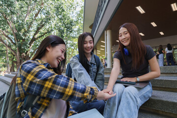 Naklejka premium Asian students stacking hands showing teamwork and friendship