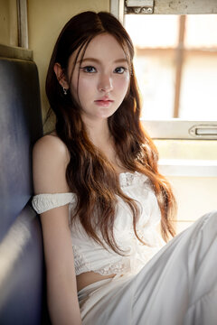 Social media trend in Thailand, Portrait of a stylish young Asian woman on a vintage train. Seated by the window, soft natural light creates a beautiful and timeless aesthetic.