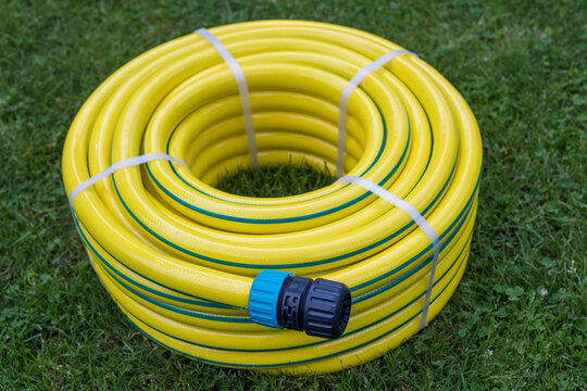 New Coiled Yellow Garden Hose on Green Grass
