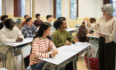 Obraz premium Teacher interacting with diverse students attending lecture in university classroom