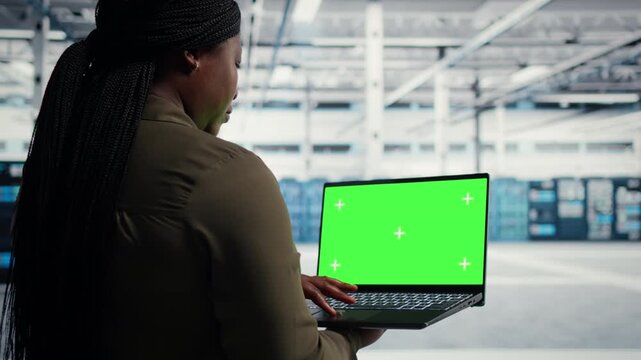 Chroma key laptop supports hardware inspection in a server farm with a replaceable display for technology workflow mockups.