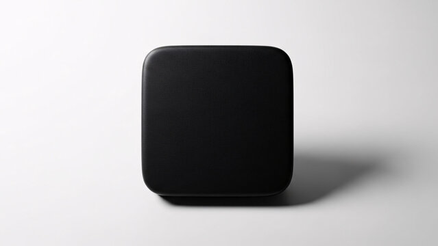 Minimalist black square speaker with rounded edges on a plain white background for modern home audio design and sleek technology aesthetics
