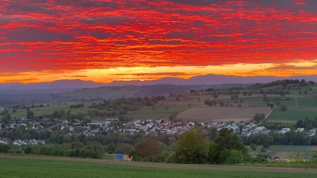 The village of Binzen, Baden-W&uuml;rttemberg, bathed in the sunset, with the mountains in the background cast in dark hues, zoom in shot