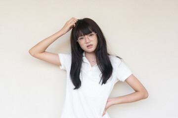 Fototapeta premium Puzzled Young Asian Woman in Glasses Scratching Head, Deeply Thinking About a Problem