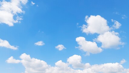 Obraz premium Clear blue sky with beautiful fluffy white clouds on a sunny summer day. Peaceful nature background featuring soft cloud formations and a bright blue sky. Sky view with a soft sky gradient.
