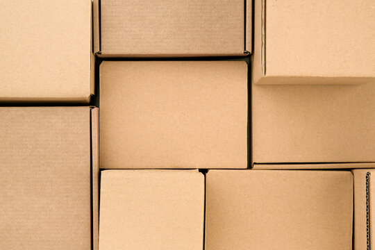Brown cardboard boxes stacked as full frame packaging background, kraft paper texture for shipping, delivery, logistics, warehouse storage, ecommerce orders, moving service, retail business, parcel